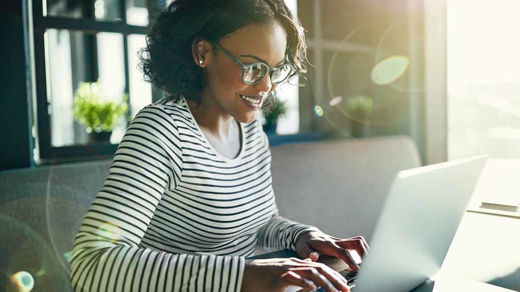 mulher feliz no computador contratando empréstimo pessoal online